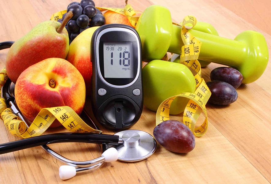 Glucose meter with medical stethoscope, fruits and dumbbells